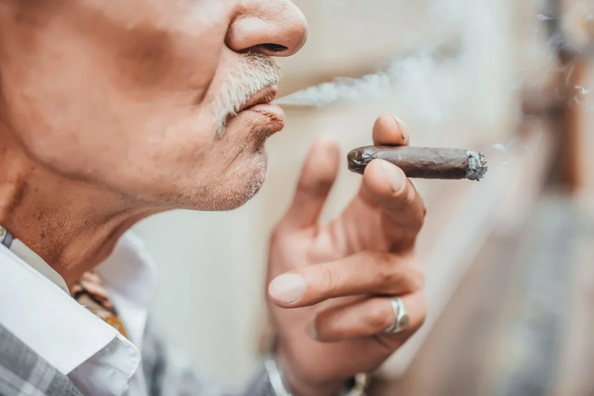 Homem com barba fumando seu charuto
